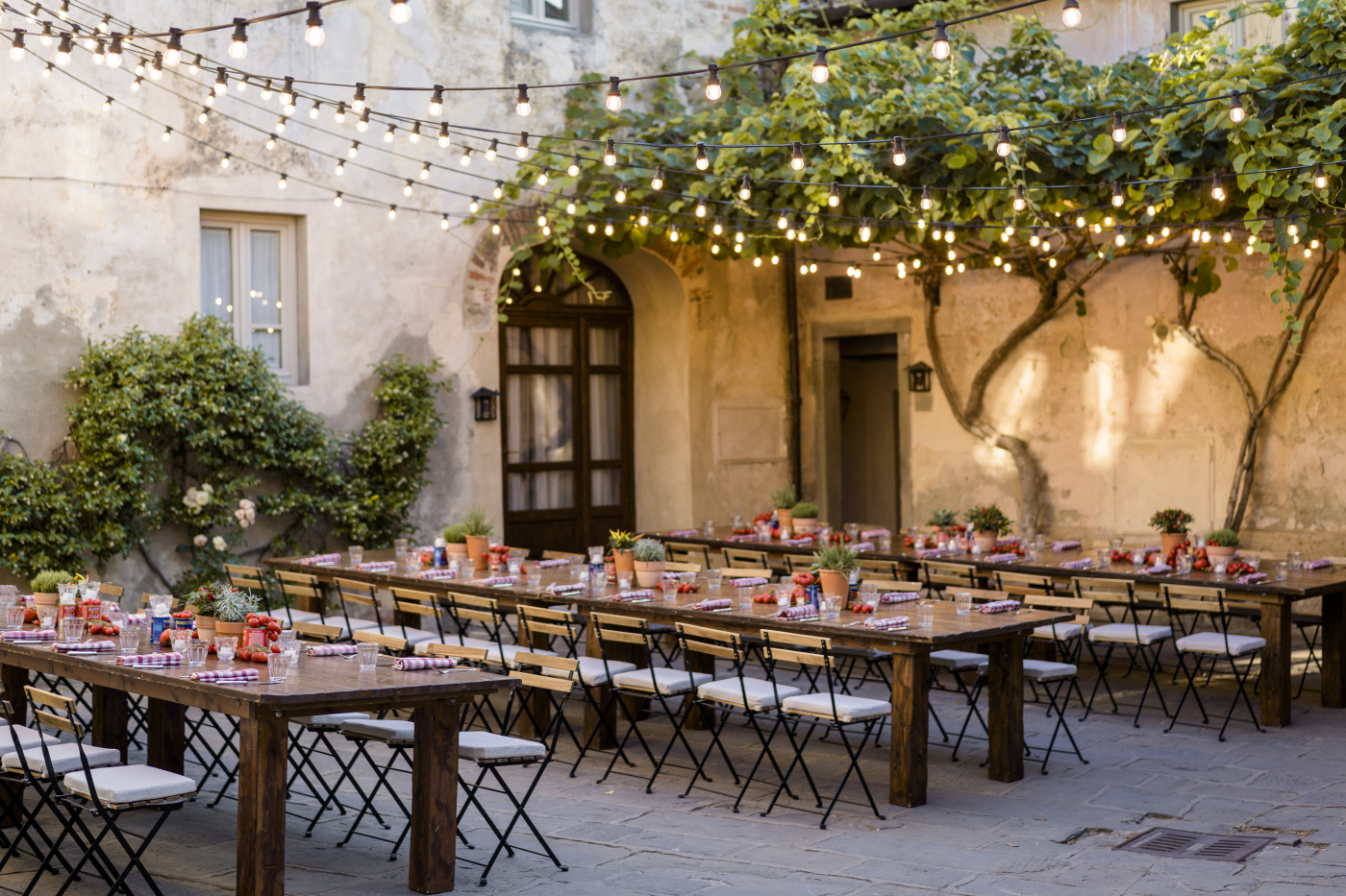 Wooden tables and rustic chairs for a market style welcome party in Italy
