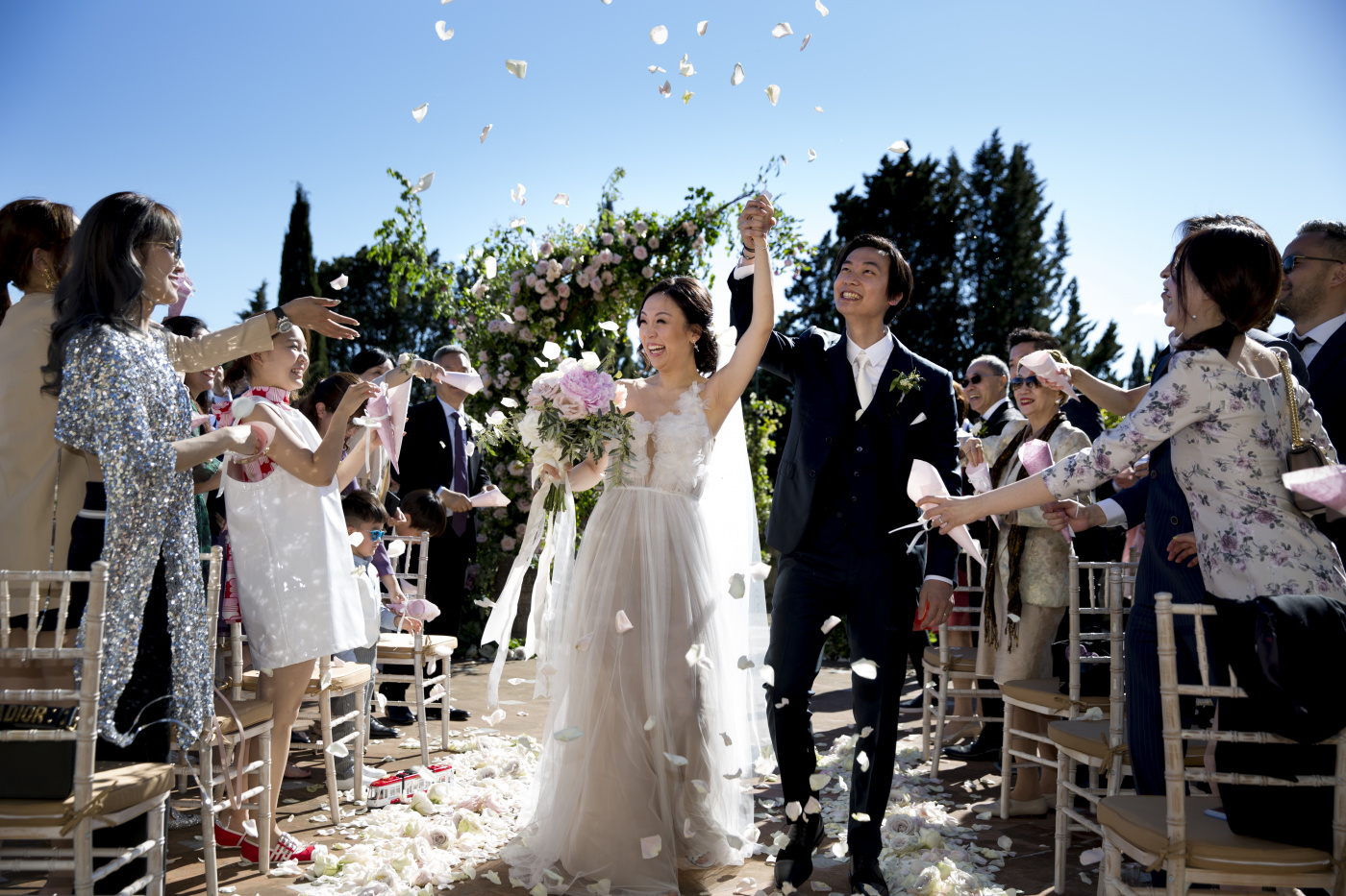 Bride and groom along the ceremony aisle with petals