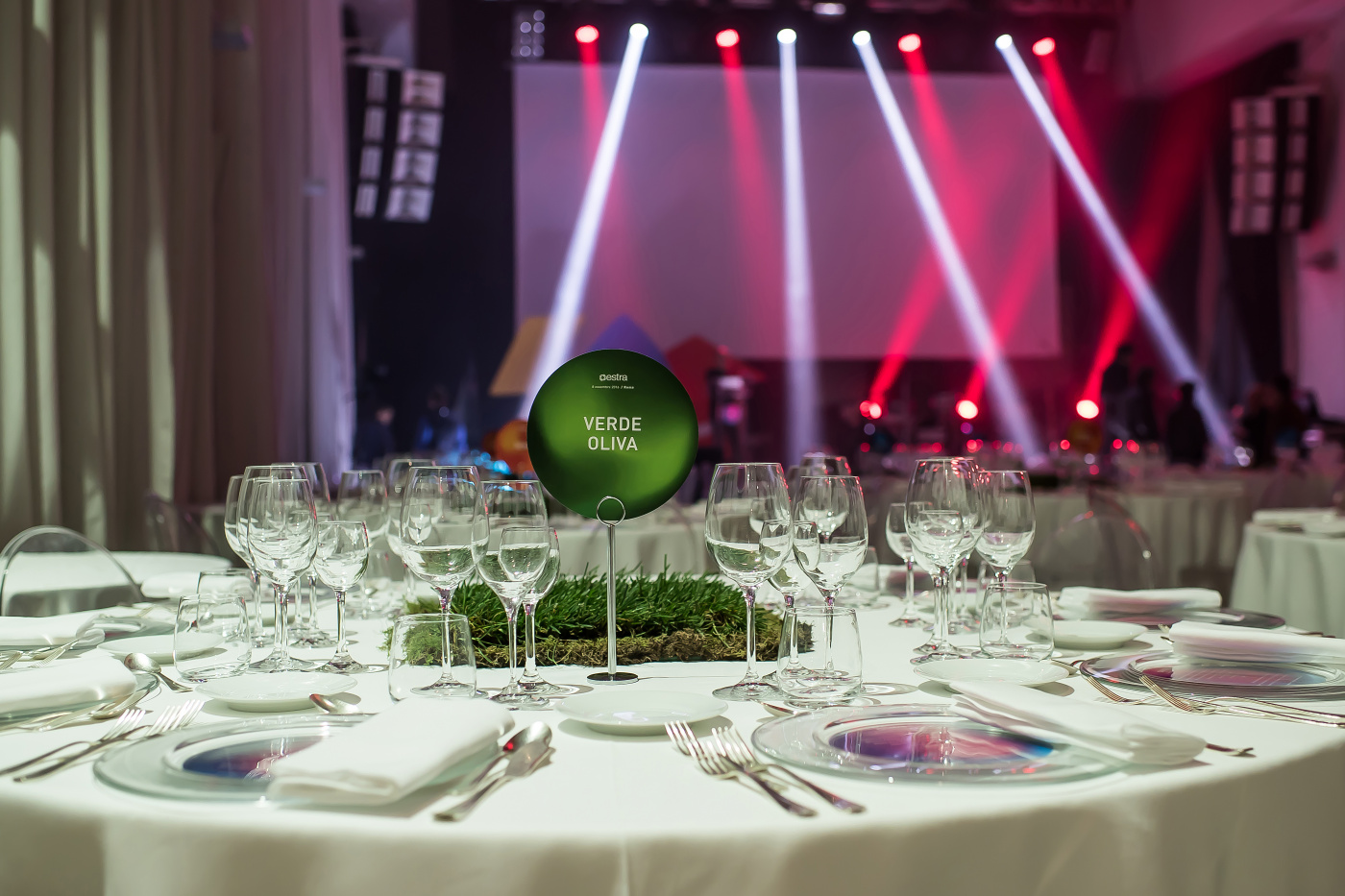 light design for event in rome with round table decored with grass