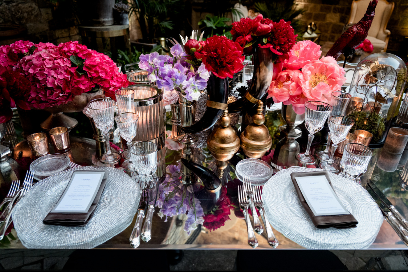 Luxury table setting with mirror table, fuxia and red flowers in jungle theme